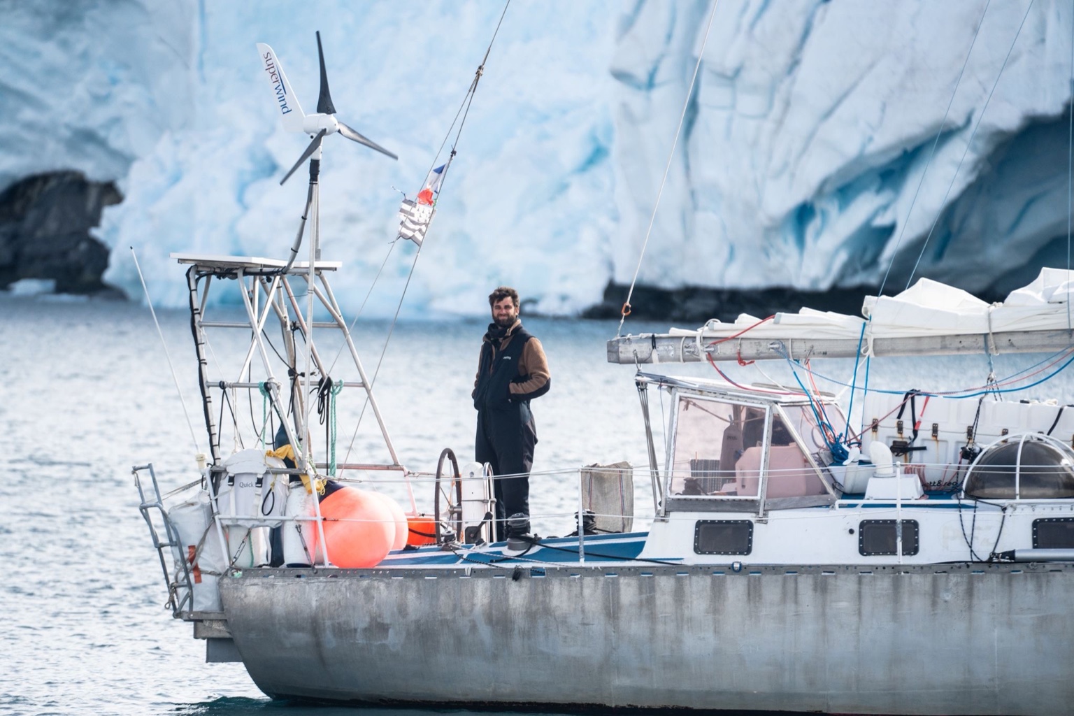 Yann Krzemien à bord de Ti Kamak devant un glacier
